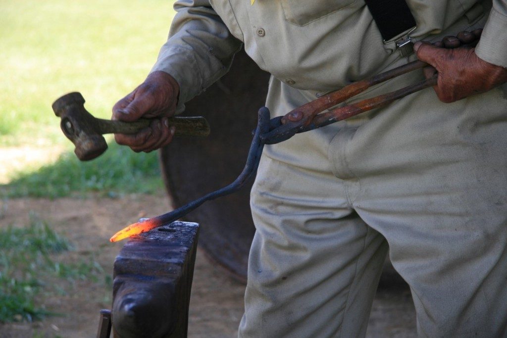 Herrero forjando metal.